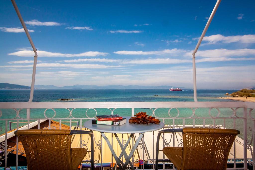 a table on a balcony with a view of the ocean at Plaza in Aegina Town