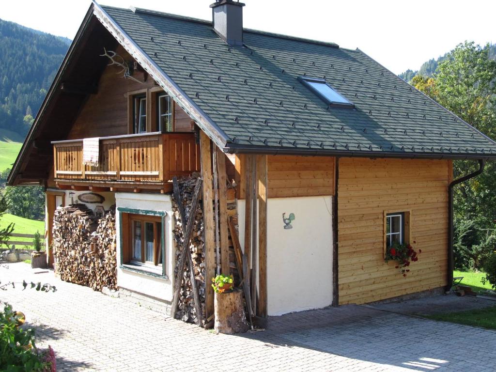 ein Holzhaus mit einer Veranda und einem Balkon in der Unterkunft Haus Sonnenalm in Forstau