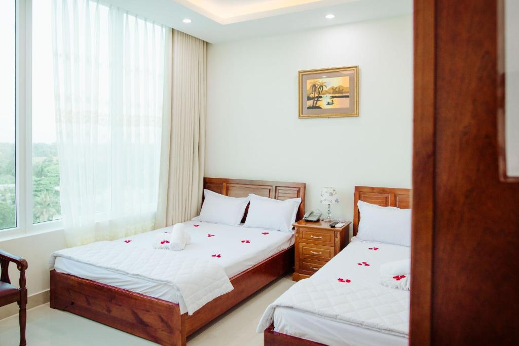 a bedroom with two beds and a window at Nhat Nga Hotel in Vung Tau