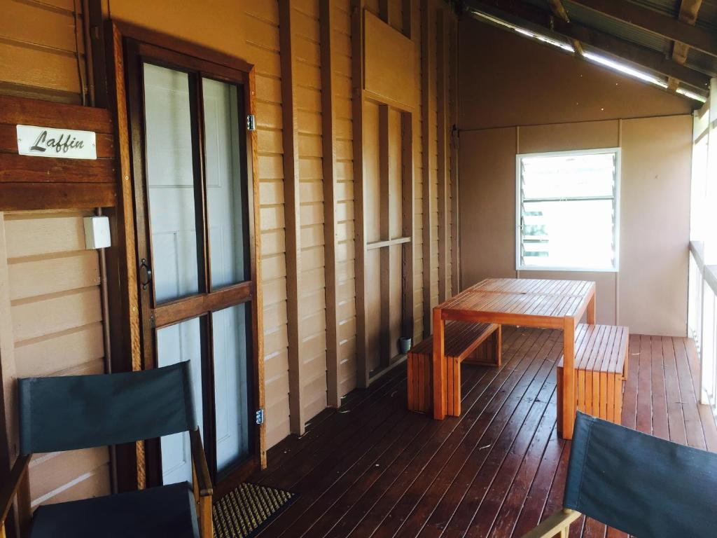 Zimmer mit einem Holztisch und Stühlen auf einer Veranda in der Unterkunft Cottage on Cork -Laffin Cottage in Winton