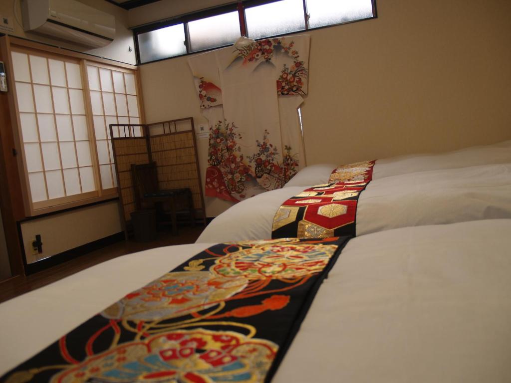 een hotelkamer met 2 bedden en een raam bij Kyomaru in Kyoto