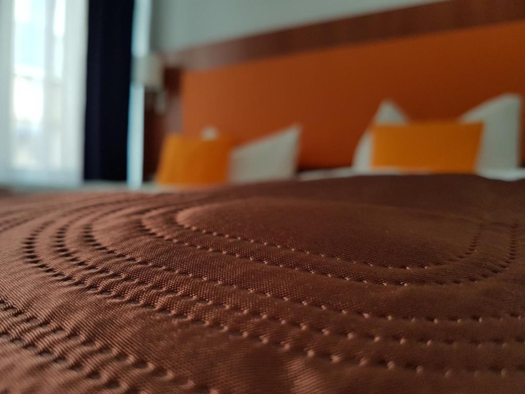 a close up of a brown bedspread on a bed at Hotel Amber Altstadt in Stralsund