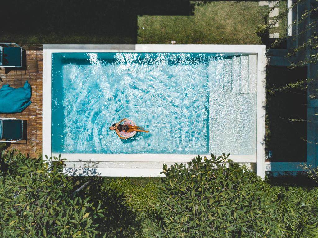 a person swimming in a pool in the water at Nazeki Villa in Uluwatu