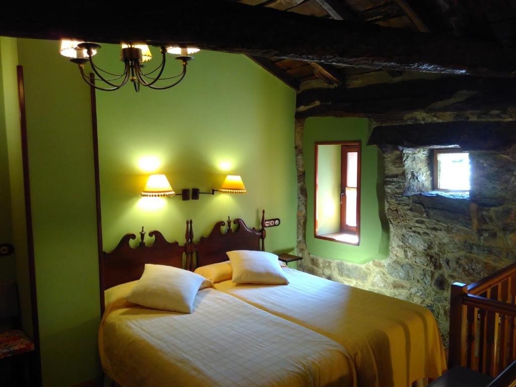1 dormitorio con 1 cama grande y paredes verdes en Hotel y AR Palacio Flórez Estrada, en Pola de Somiedo