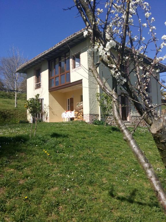 Una casa blanca con un árbol delante. en Alojamiento Rural LA GLORIA II, en Cervera