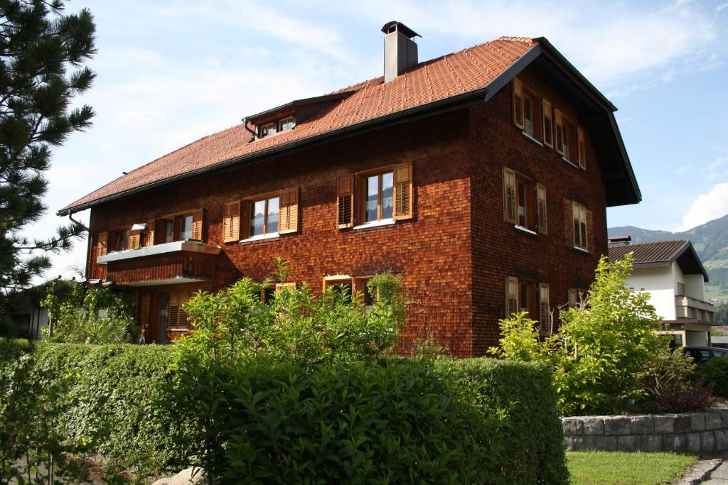 ein großes Backsteinhaus mit rotem Dach in der Unterkunft mama käthe - Apartments in Nenzing