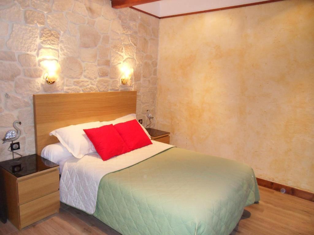 1 dormitorio con 1 cama con almohada roja en Savoy Hotel en Le Bourget-du-Lac