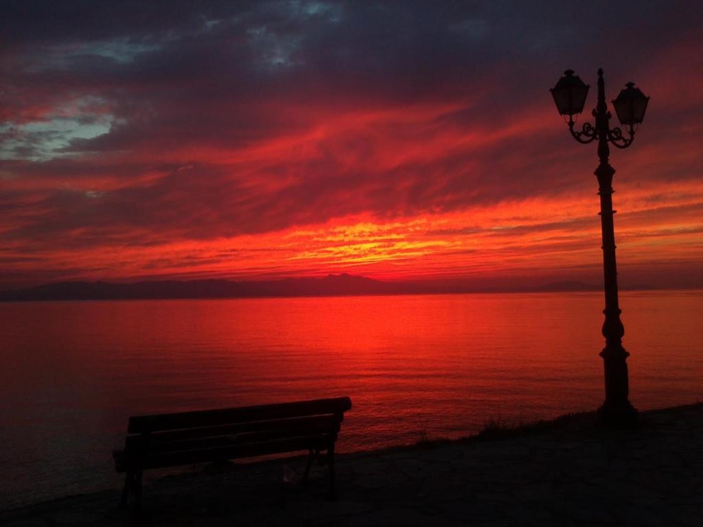 a bench next to a street light and a sunset at Marathon Eco Stay in Marathon