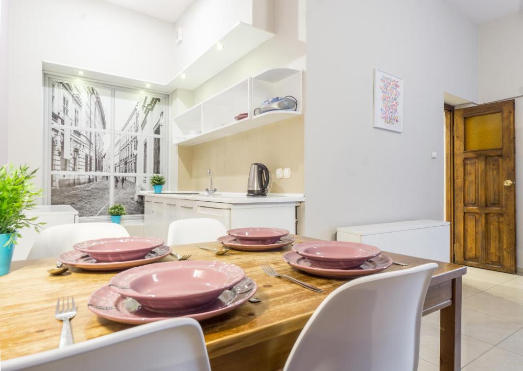 cocina y comedor con mesa de madera y sillas en Apartamenty Idylla, en Cracovia