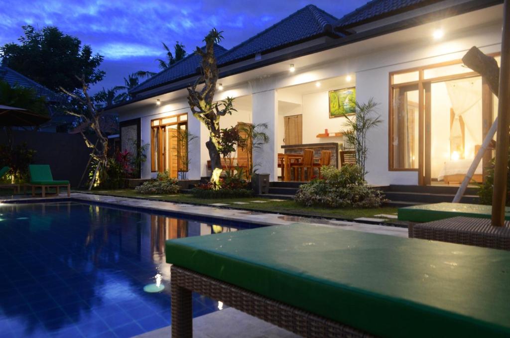 a house with a swimming pool in front of a house at Villa Ole in Ubud