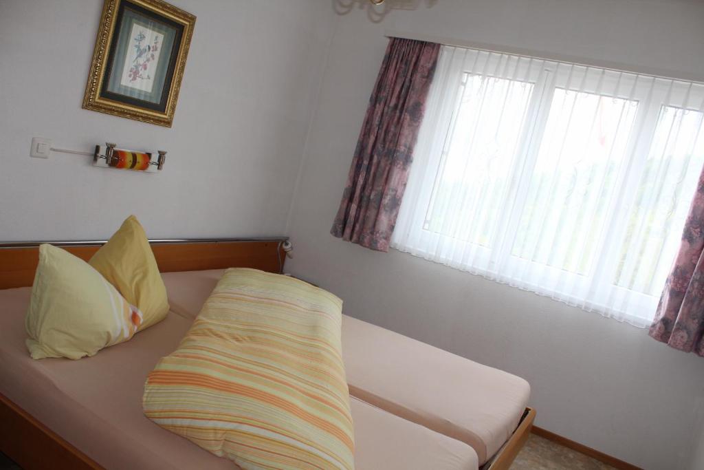 Bett in einem Zimmer mit Fenster und Kissen in der Unterkunft Apartment Hulfteggpass in Mühlrüti