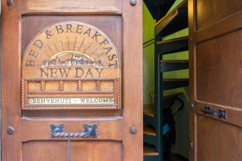 una puerta de madera con un nuevo cartel de día en B&B New Day en Assisi