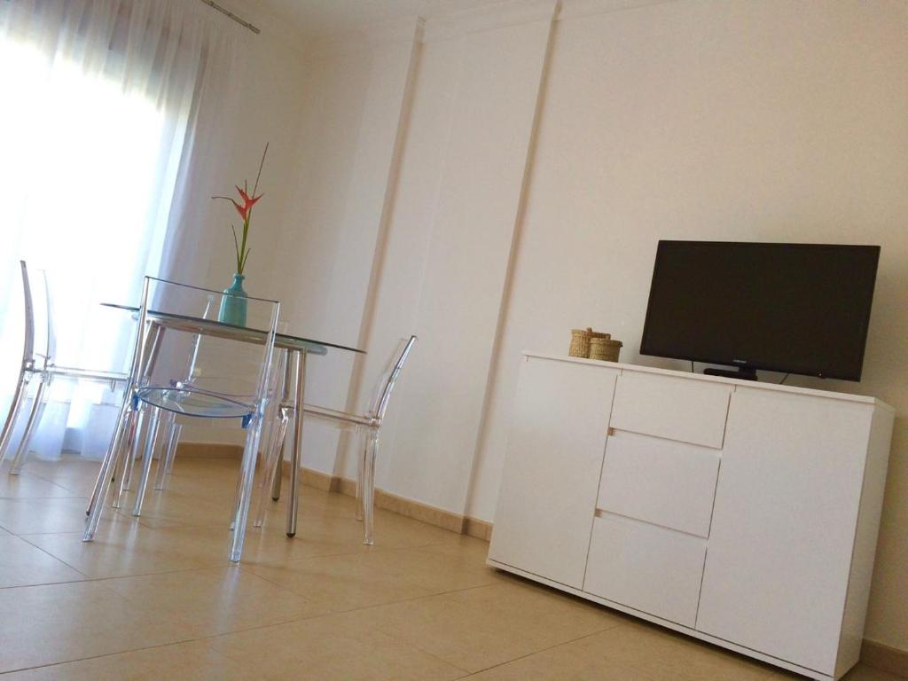 a dining room with a table with a tv on it at Hola Apartments 1-30 in Playa de San Juan