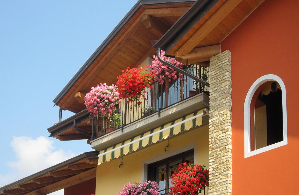 a building with flower baskets on a balcony at B&B Doria Valle Maira in Roccabruna