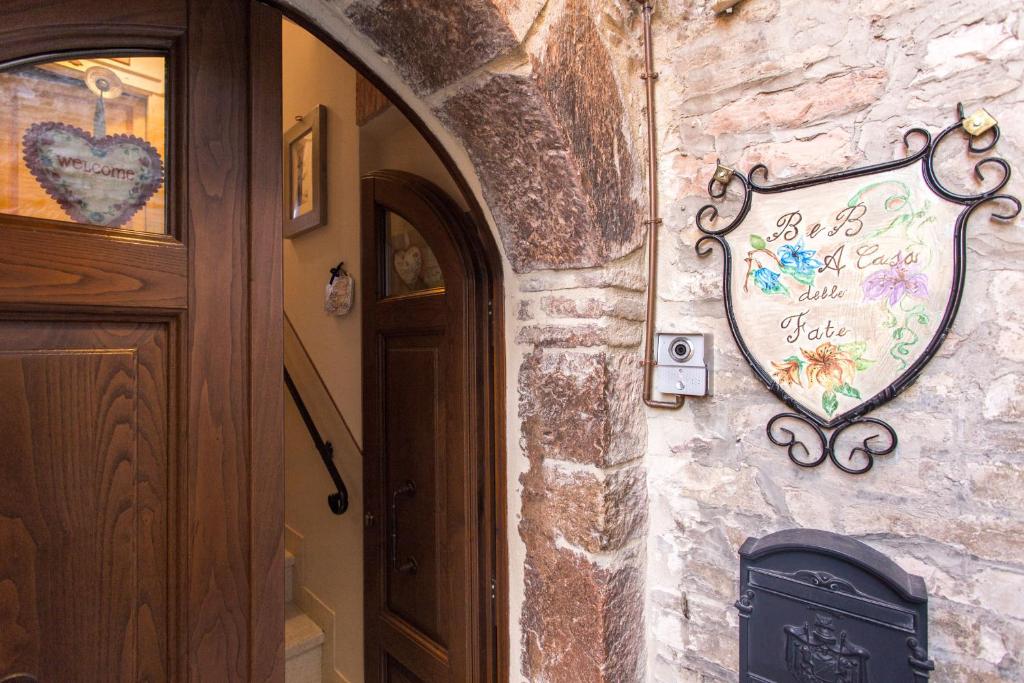 un muro di pietra con un segno cardiaco accanto a una porta di Bed and Breakfast A casa delle Fate ad Assisi