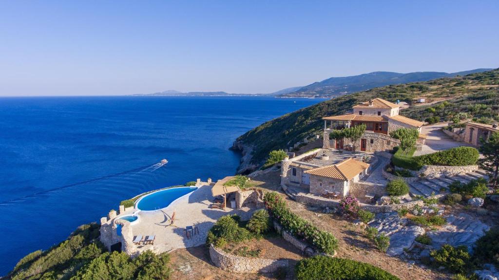 an aerial view of a house on a hill next to the ocean at Blue Caves Villas - exceptional Villas with private pools direct access to the sea in Koríthion