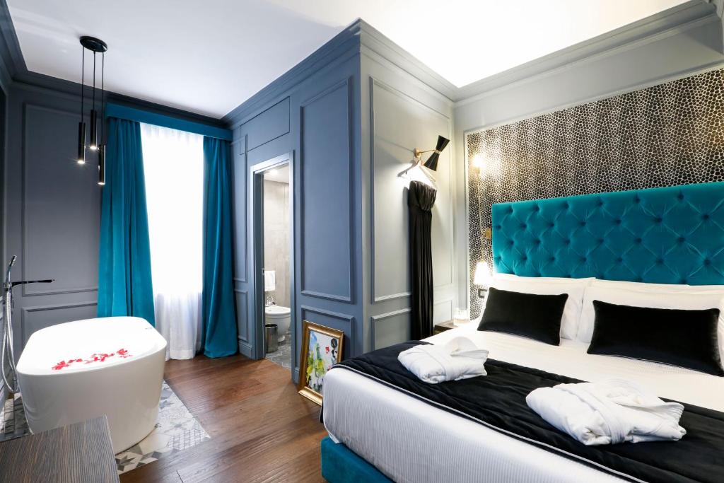 una camera con un grande letto con testiera blu di Saint B Boutique Hotel STB a Roma
