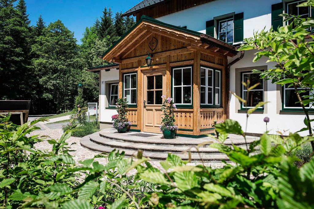 バート・アウスゼーにあるWaldruhe - Bett, Frühstück & ein Lächelnの木製ポーチとパティオ付きの家