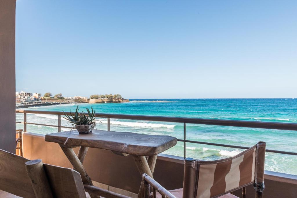 a table on a balcony overlooking the ocean at Nais Apartments & Studios in Chania Town