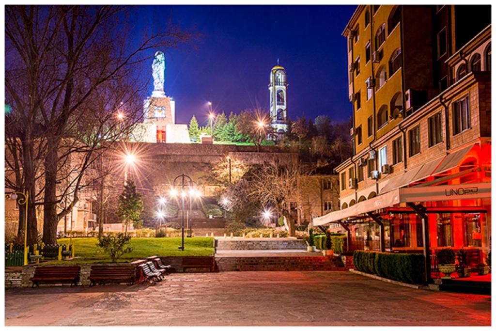a city street at night with a clock tower at Magnolia Guest house in Haskovo