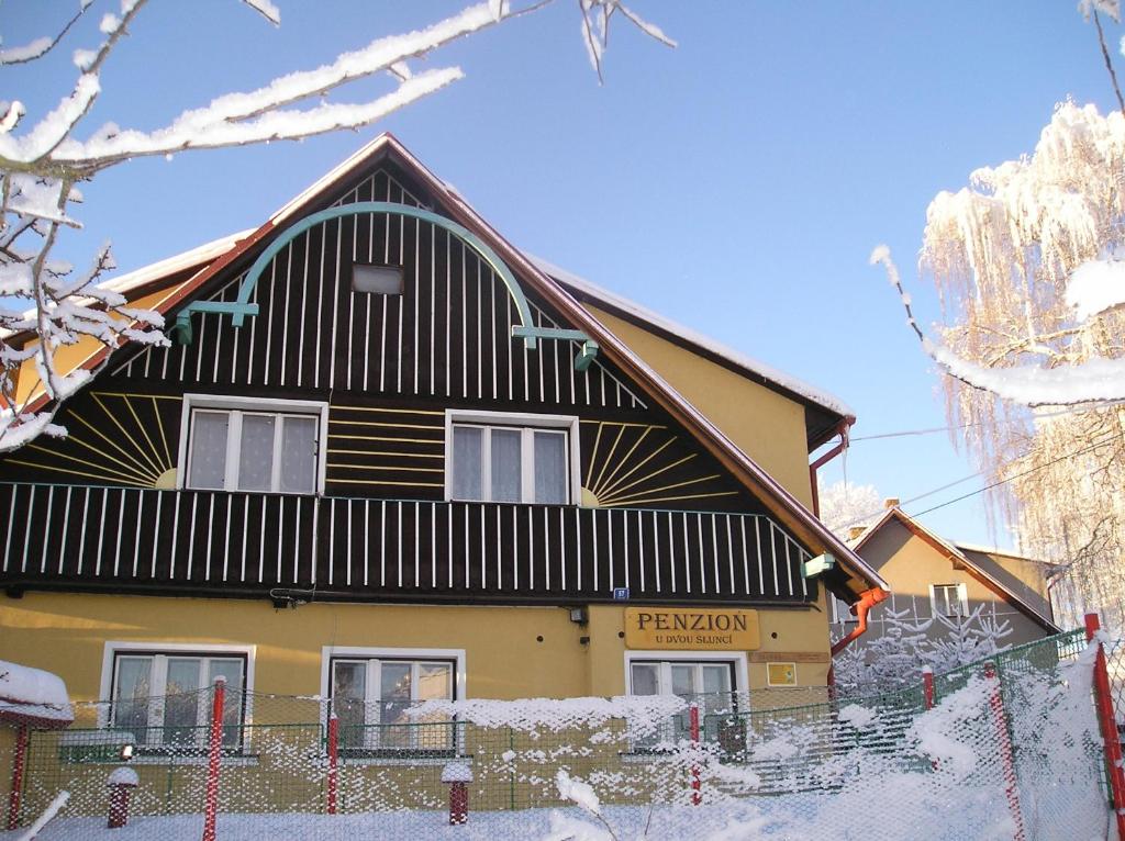 a house with a black and white roof at Penzion U Dvou slunci in Stachy