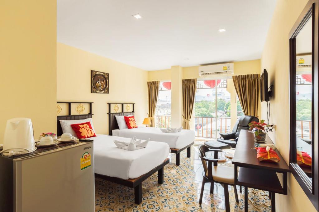 Habitación con 2 camas, sofá y mesa. en Le Hua Hotel, en Phuket