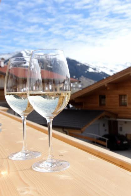 two glasses of white wine sitting on a table at Ferienwohnungen H&P in Alpbach