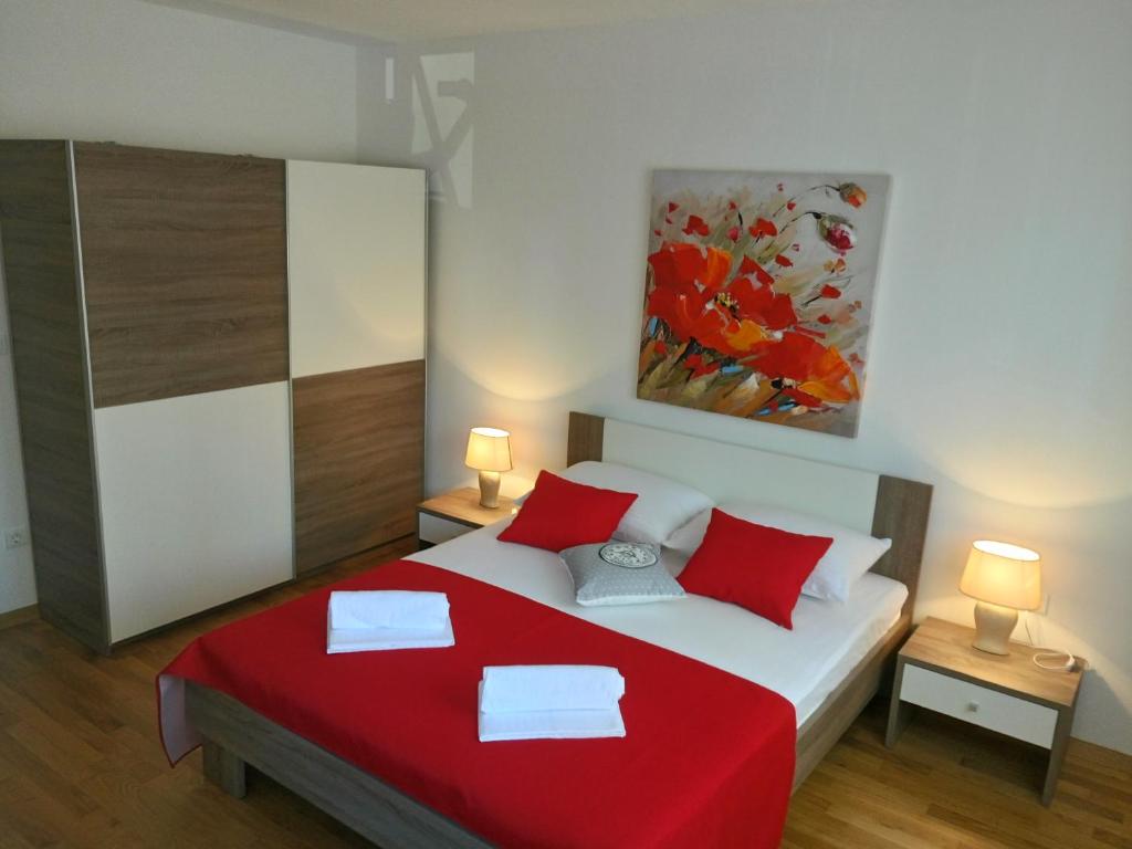 een slaapkamer met een rood en wit bed met 2 lampen bij Petra apartment in Zadar