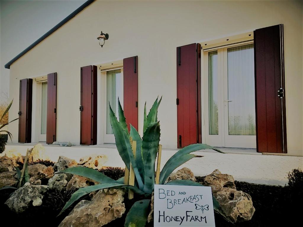 una señal frente a una casa con una planta en Agriturismo Honey Farm en Piazzola sul Brenta