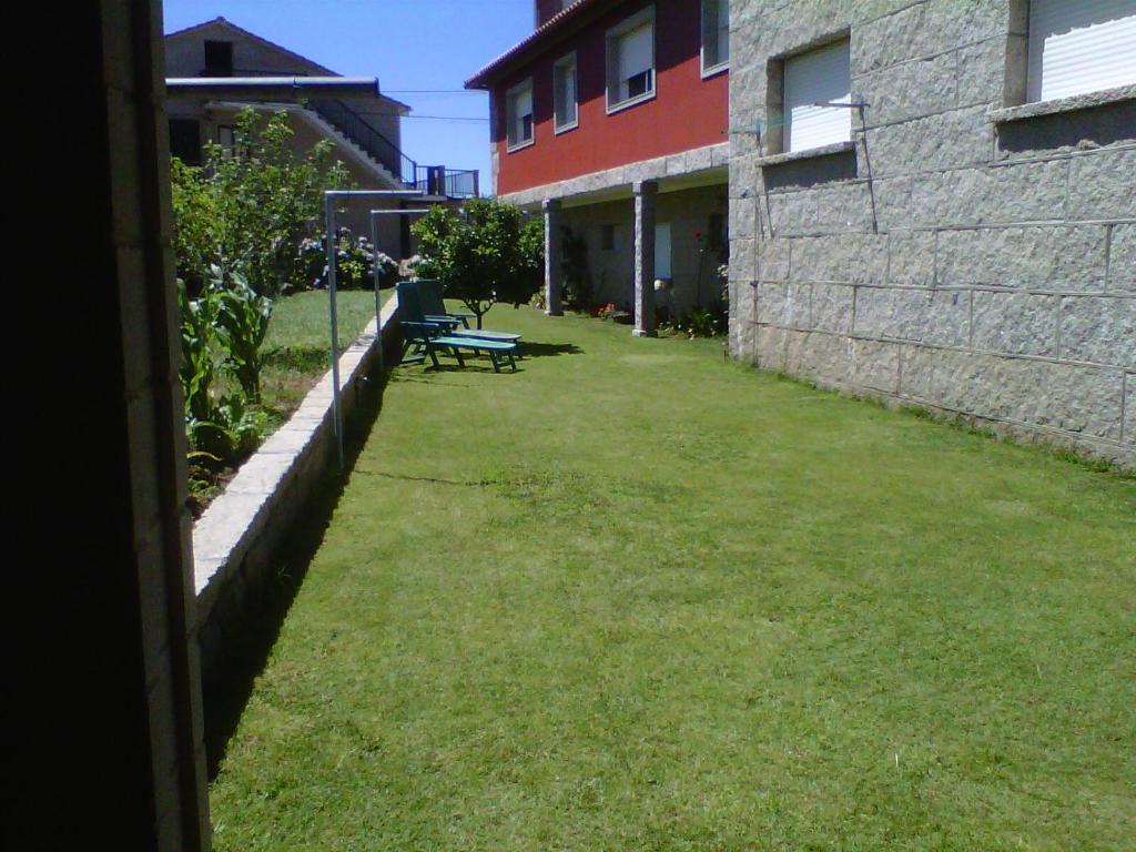 un patio con un banco junto a un edificio en Verde y Mar, en Noalla