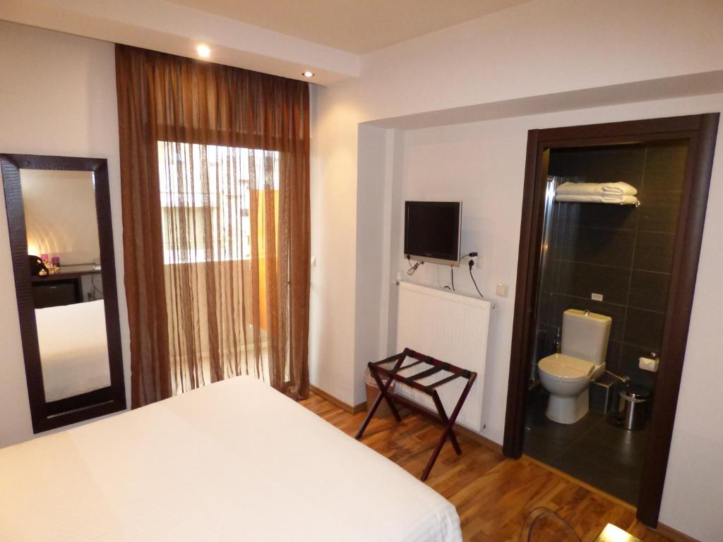 a bedroom with a white bed and a toilet at Athens Habitat in Athens