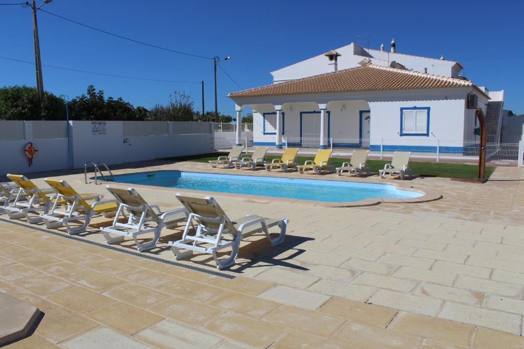 a group of lounge chairs and a swimming pool at Villas Nobre in Guia