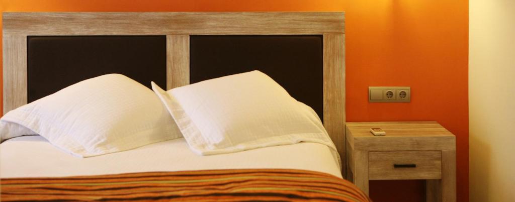 ein Schlafzimmer mit einem Bett mit zwei Kissen und einem Tisch in der Unterkunft Casa Santos in Albalate de Cinca