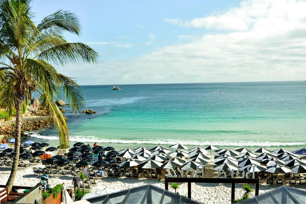 邦比尼亞斯的住宿－波拉波拉旅館，海滩上放着一把遮阳伞,大海
