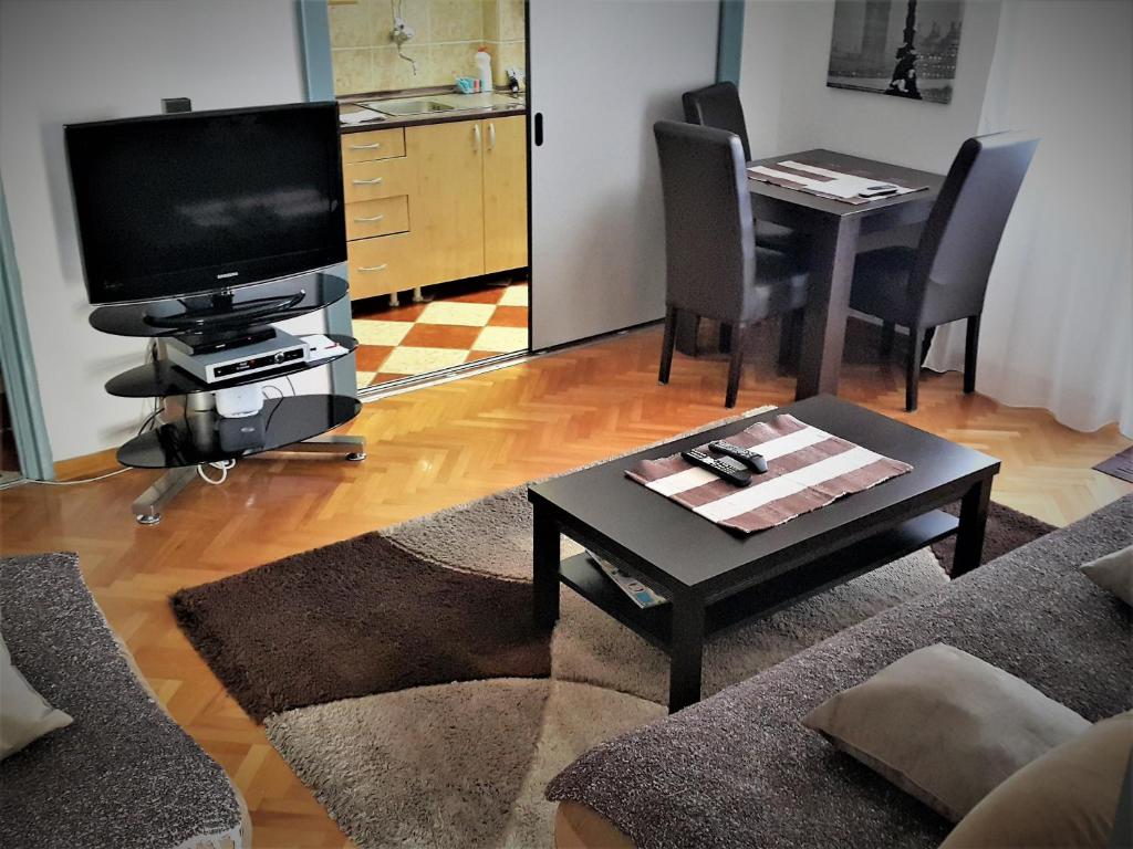 a living room with a tv and a coffee table at Centre Point Apartment in Podgorica