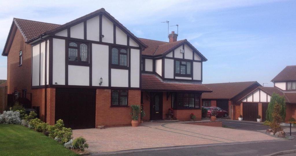 a large black and white house with a driveway at The Cedars House B&B in Nuneaton