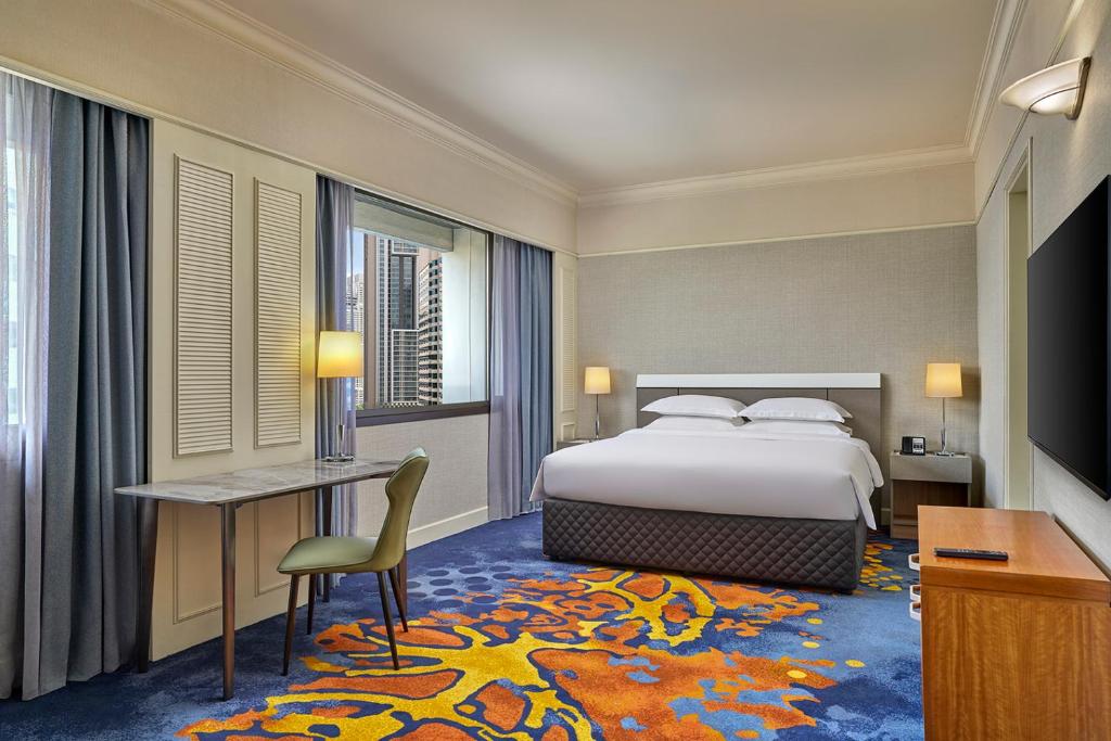A double room with a window-side desk and a partial city view.