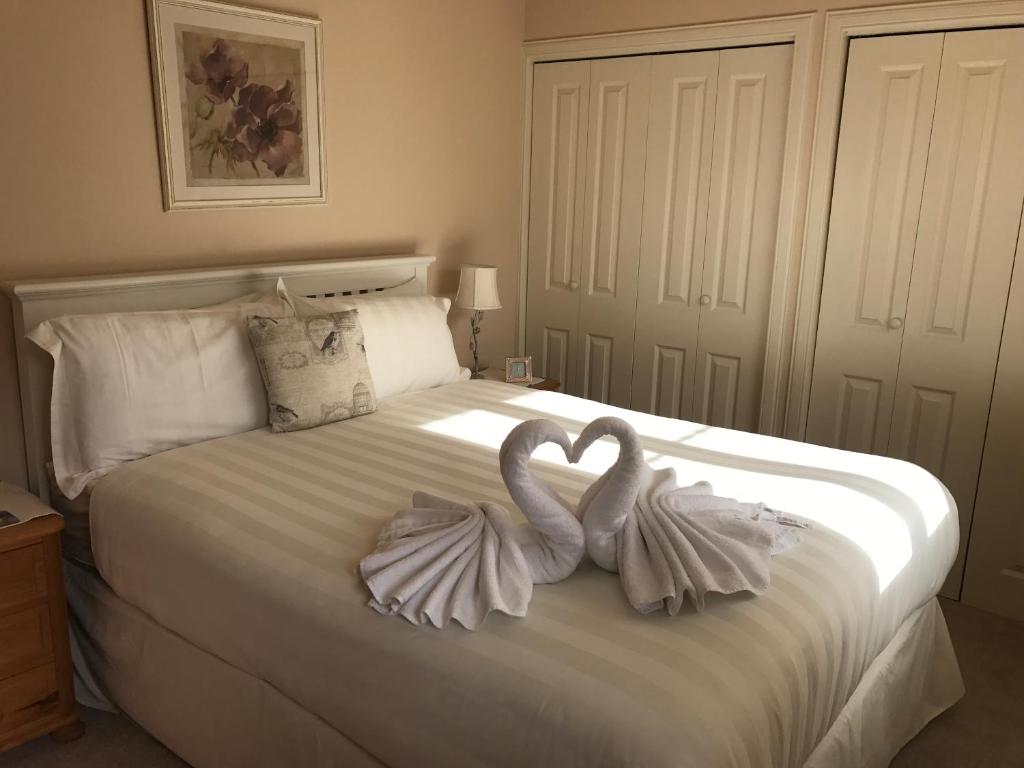dos cisnes están sentados en la parte superior de una cama en Wellingtonia Apartment en Inverness