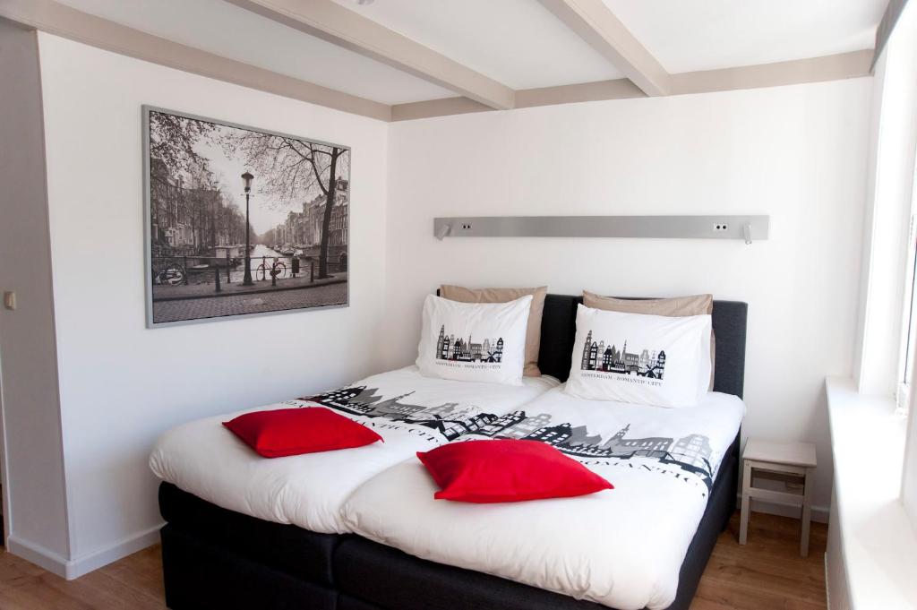 a bedroom with a bed with red pillows on it at Residence Flower Market in Amsterdam