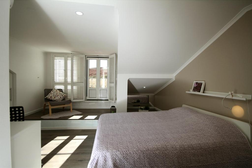 um quarto branco com uma cama e uma janela em Alfama Right Point em Lisboa