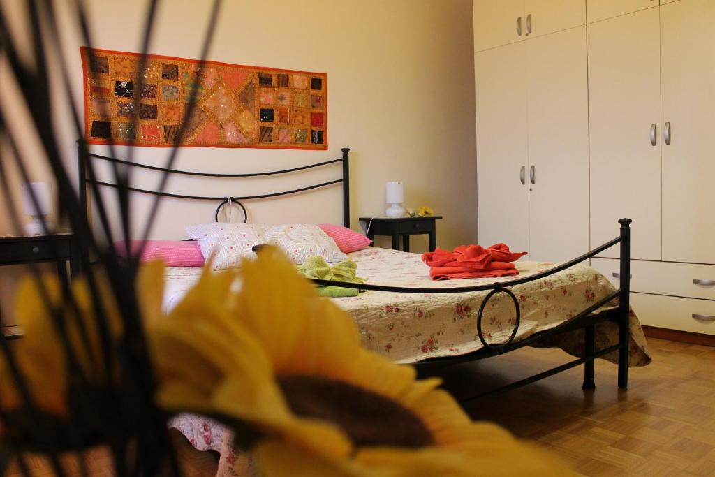 una camera da letto con un letto in primo piano con un fiore di Appartamento Galileo a Padova