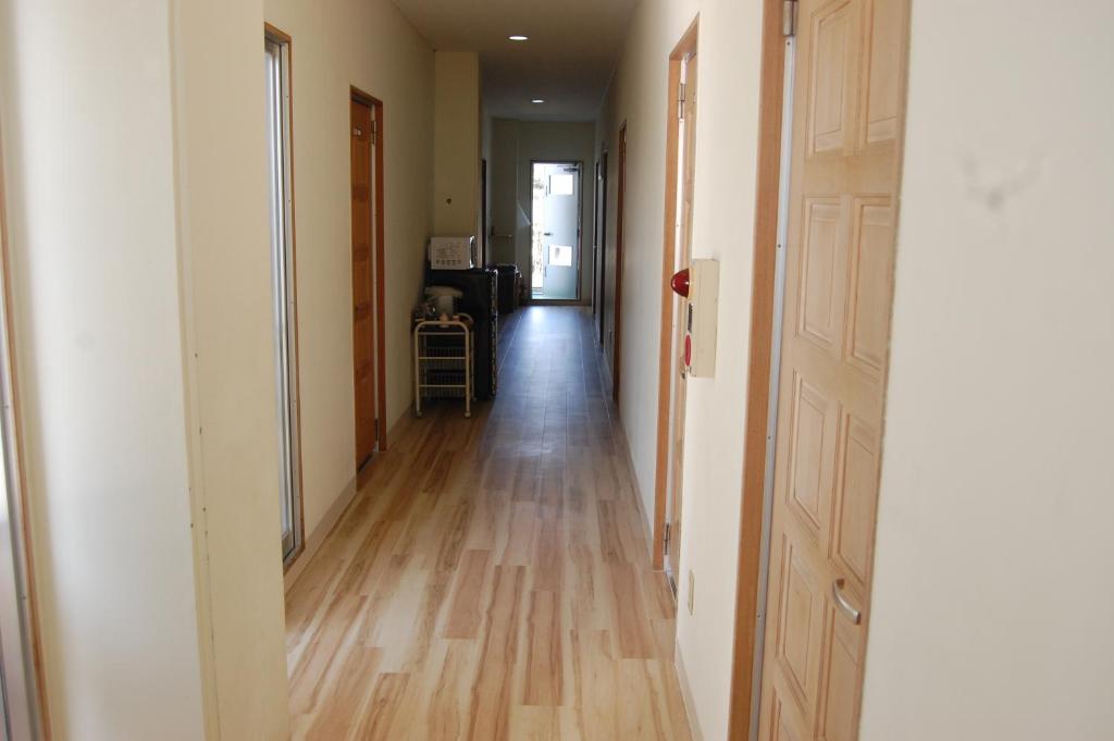 an empty hallway with a wooden floor in a house at Minshuku Namisou in Iriomote