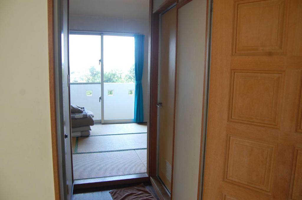 a hallway with a mirror and a door with a door at Minshuku Namisou in Iriomote