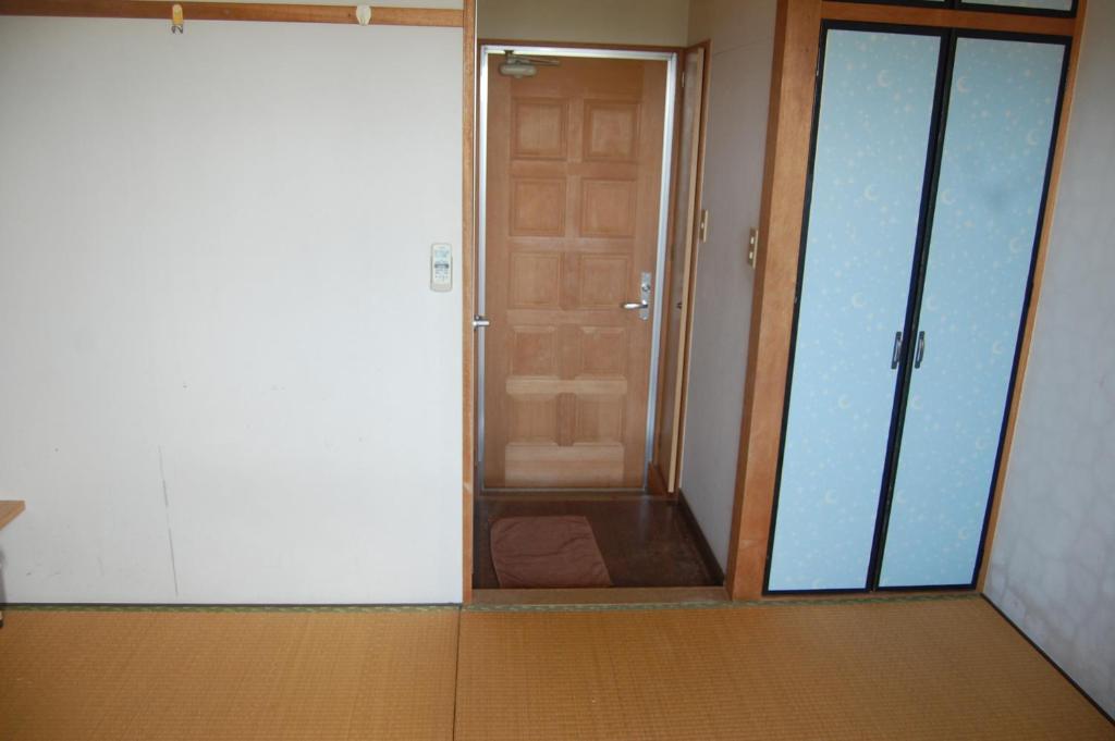 an empty room with a door and a room with a hallway at Minshuku Namisou in Iriomote