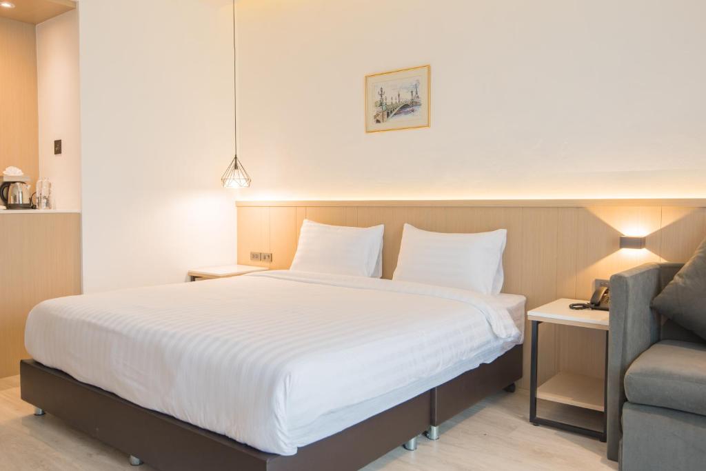 A large double bed sits beside a compact sofa, desk and beverage station.
