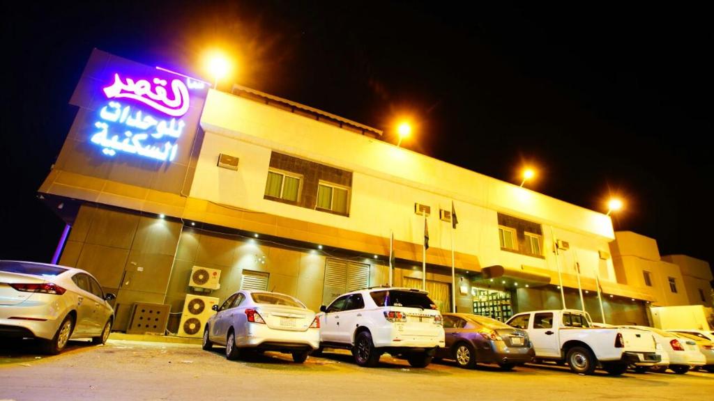 un grupo de coches estacionados fuera de un edificio por la noche en Sama Al Qasr Al Muhammadiah, en Riad