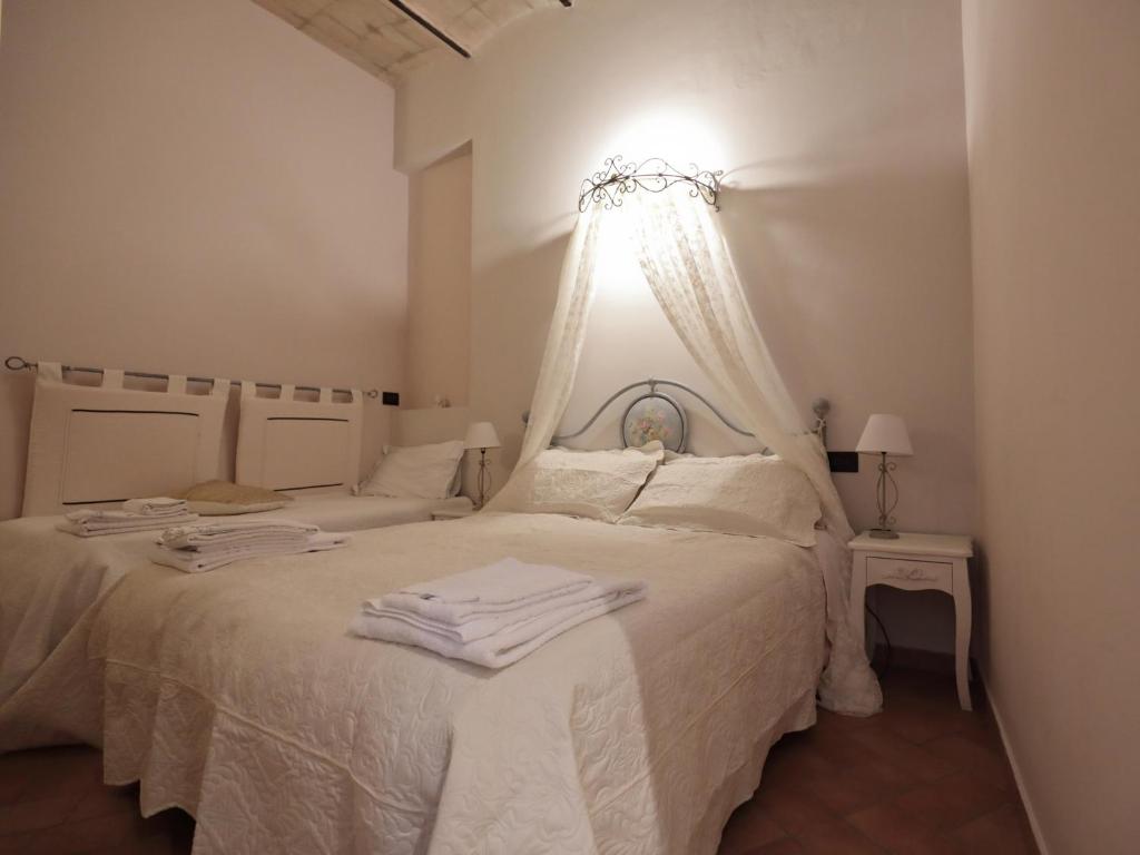 ein weißes Schlafzimmer mit einem Bett mit weißer Bettwäsche in der Unterkunft Residenza Raffaello in Foligno