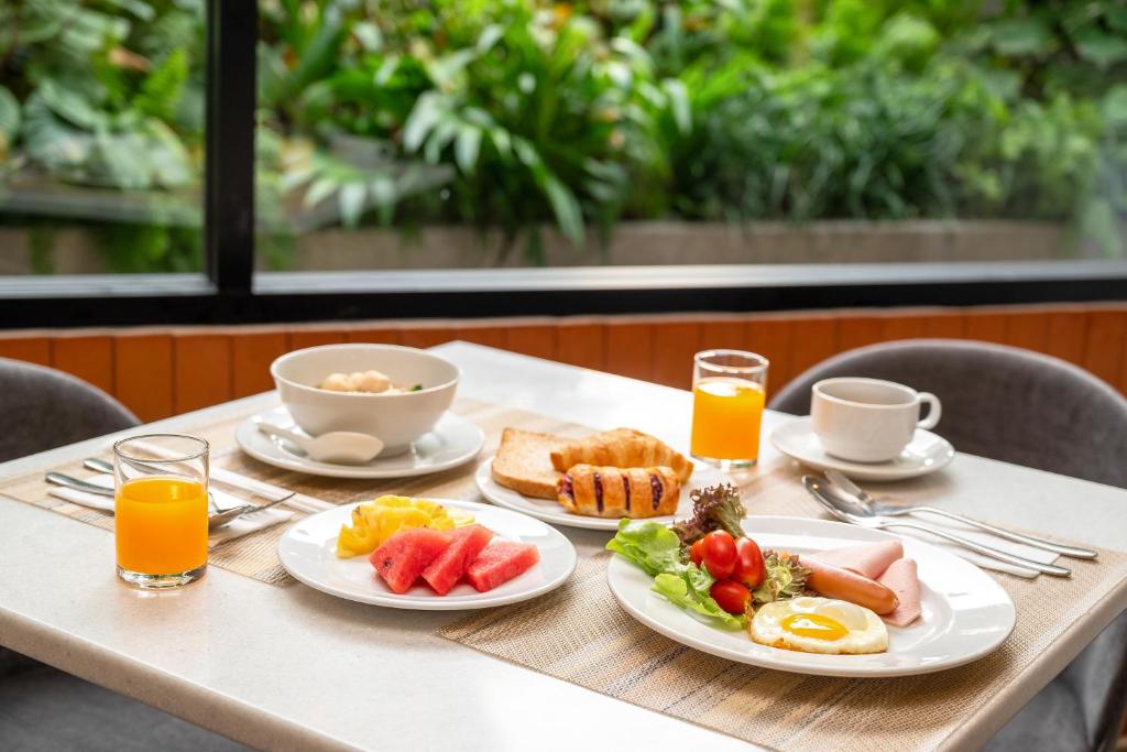 A plated breakfast for two beside a leafy window.