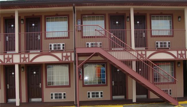 un edificio con una escalera roja en su lateral en Colonial Inn Hammond, en Hammond