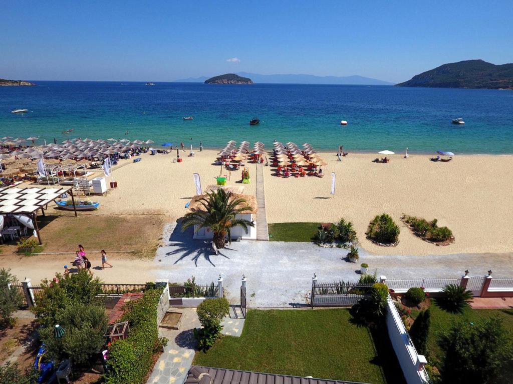 una playa con sombrillas y gente en la playa en Villa Mediterrane Hotel, en Nea Iraklitsa